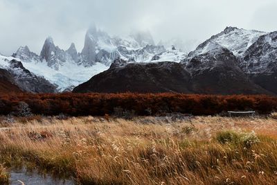 Scenic view of snowcapped mountains against cloudy sky