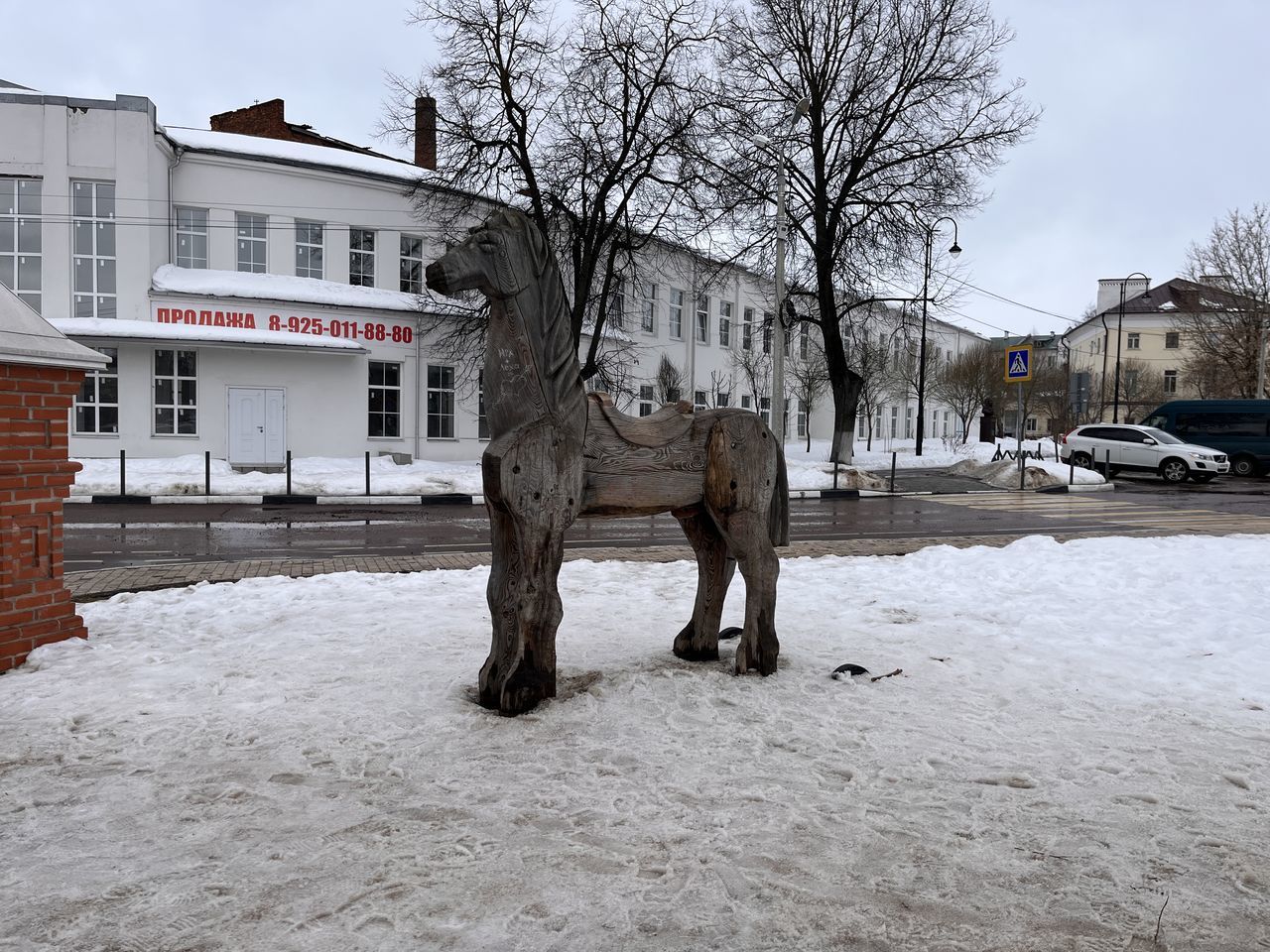 winter, snow, architecture, building exterior, built structure, city, cold temperature, tree, building, nature, sky, bare tree, mammal, animal, street, no people, sculpture, animal themes, urban area, house, statue, residential district, day, domestic animals, art, horse, vehicle, outdoors, transportation, plant, car
