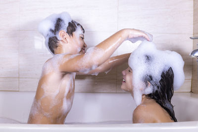 Side view of siblings in bathroom at home