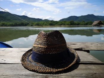 Close-up of hat on pier against lake