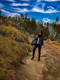 Full length of woman standing on land against sky