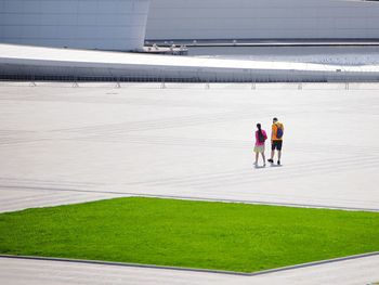 Rear view of people walking on footpath