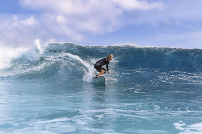 Man with surfboard surfing in sea