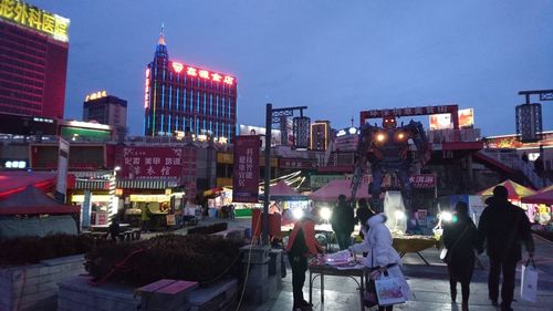 People on illuminated street at night