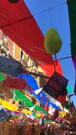 Low angle view of colorful lanterns hanging against clear blue sky