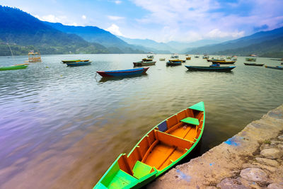 Boats moored in lake against sky