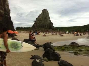 People at beach against sky