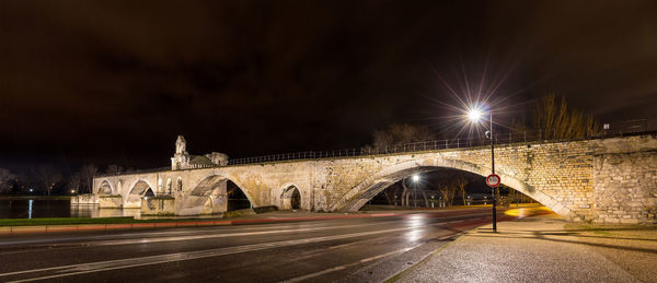 Bridge over illuminated street at night