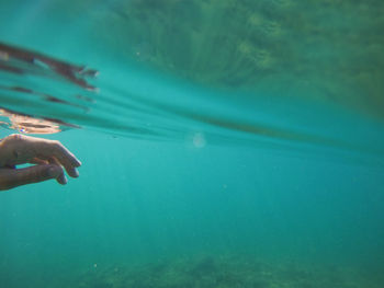 Female hand under the sea water surface