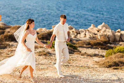 Full length of couple walking at coastline