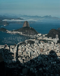 High angle view of townscape by sea against sky