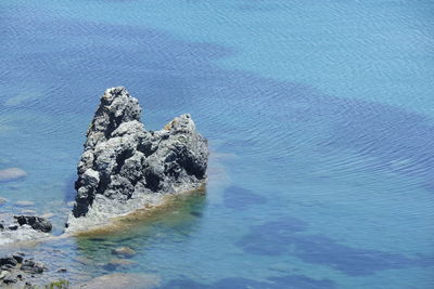 High angle view of rock in sea against sky
