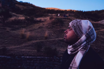 Mid adult man wearing headscarf while looking up against mountain