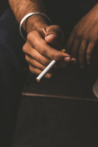 Midsection of man smoking cigarette