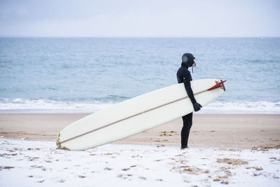 Young woman going winter surfing in snow