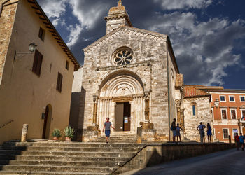 People outside historic building against sky