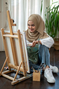 Portrait of young woman working on table