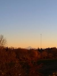 Scenic view of field against clear sky during sunset