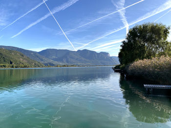 Scenic view of lake and mountains against blue sky