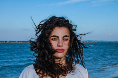 Portrait of beautiful woman at beach against sky