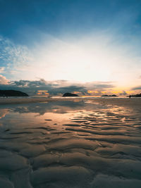 Sunrise reflections on the beach sand.