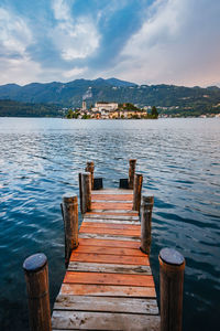 The island of san giulio with a wooden jetty in the foreground at sunset