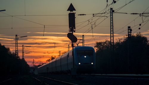 Silhouette train against sky during sunset