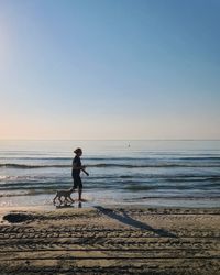 Full length of woman on beach against clear sky