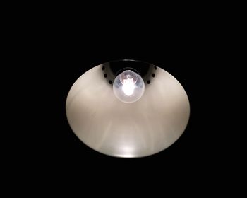 Low angle view of illuminated light bulb in darkroom