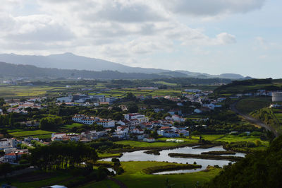 Scenic view of townscape and mountains against sky