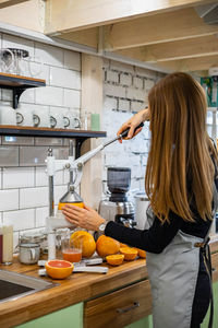 Rear view of woman preparing food in kitchen