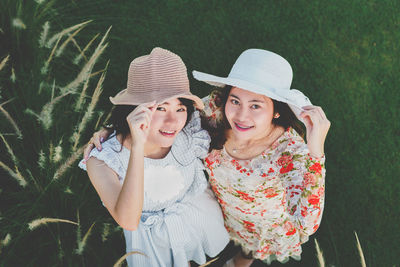 High angle portrait of female friends standing on field