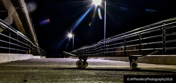 People on illuminated bridge at night