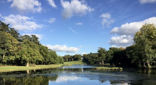 Scenic view of lake by trees against sky