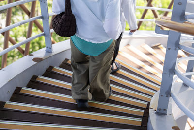 Rear view of woman standing on railing