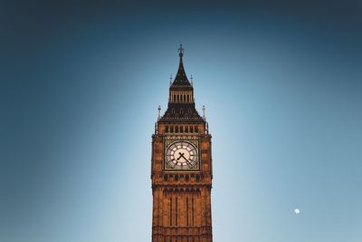 Low angle view of clock tower against clear blue sky