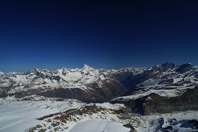 Scenic view of snowcapped mountains against clear blue sky