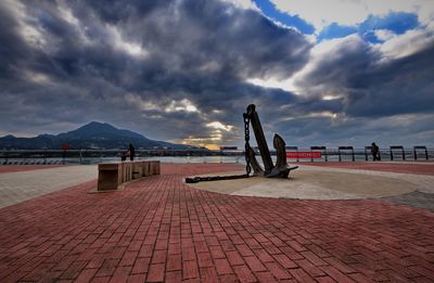 View of footpath against cloudy sky