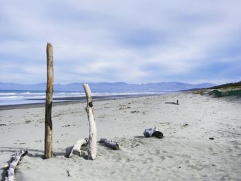 Scenic view of beach against cloudy sky