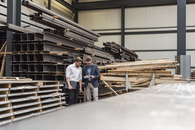 Two men using tablet in factory