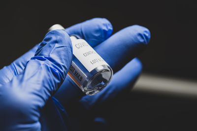 Close-up of hand holding vial