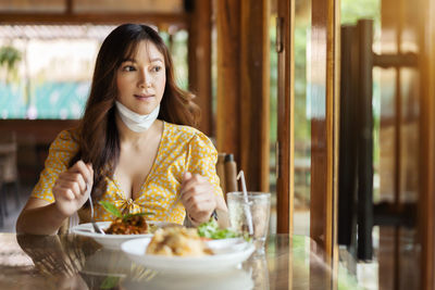 Portrait of young woman having food at restaurant