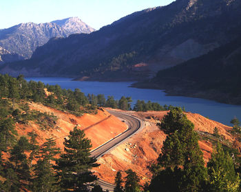 High angle view of winding road by river against mountains