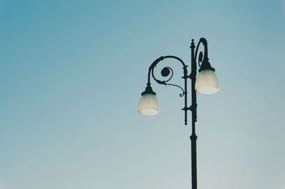 Low angle view of illuminated street light against sky