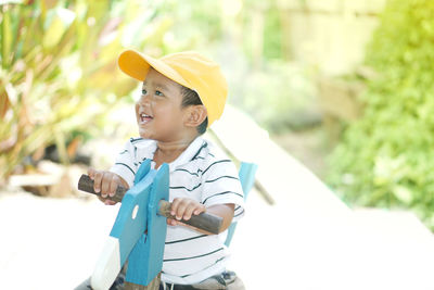 Cute boy smiling while sitting on rocking horse