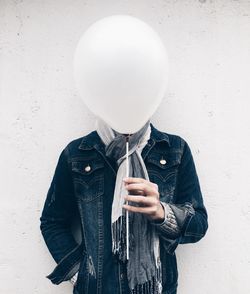 Man holding balloon in front of his face