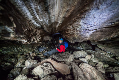 High angle portrait of woman standing amidst rock formations at jotunheimen national park