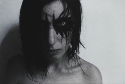 Close-up portrait of woman against gray background