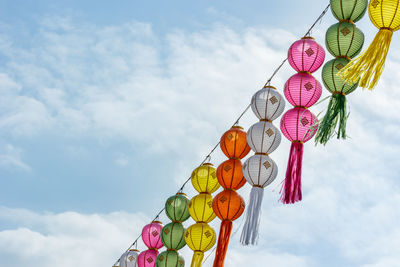 Low angle view of lanterns hanging against sky