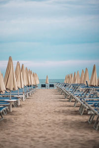 Lounge chairs and closed sunshades on beach